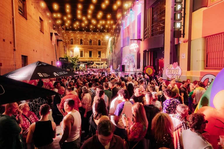Crowd gathered at Poppin Out 2025 festival in an illuminated Adelaide laneway under fairy lights, photographed by Samuel Graves.